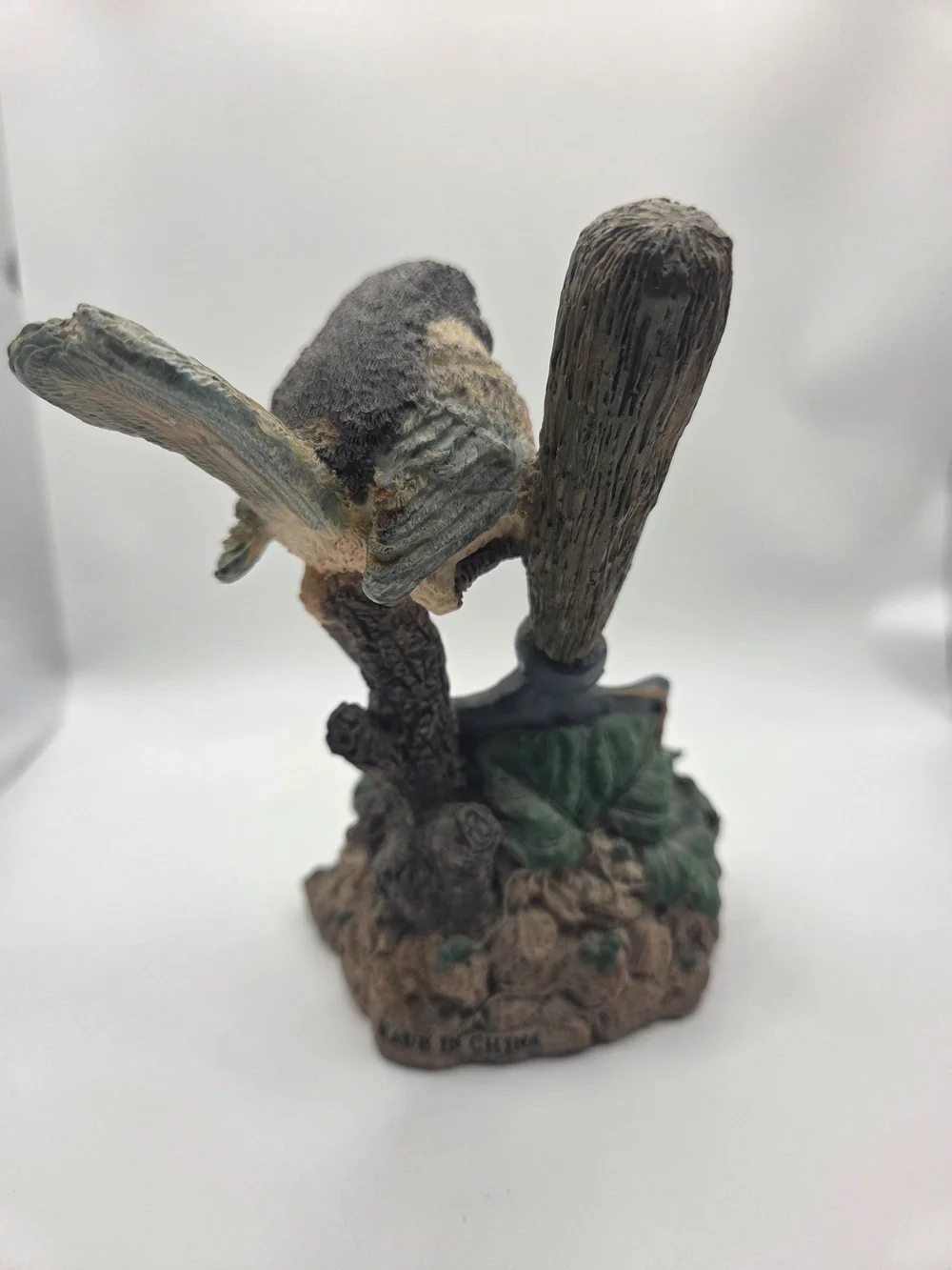Vintage resin desk clock with a bird perched on a shovel handle